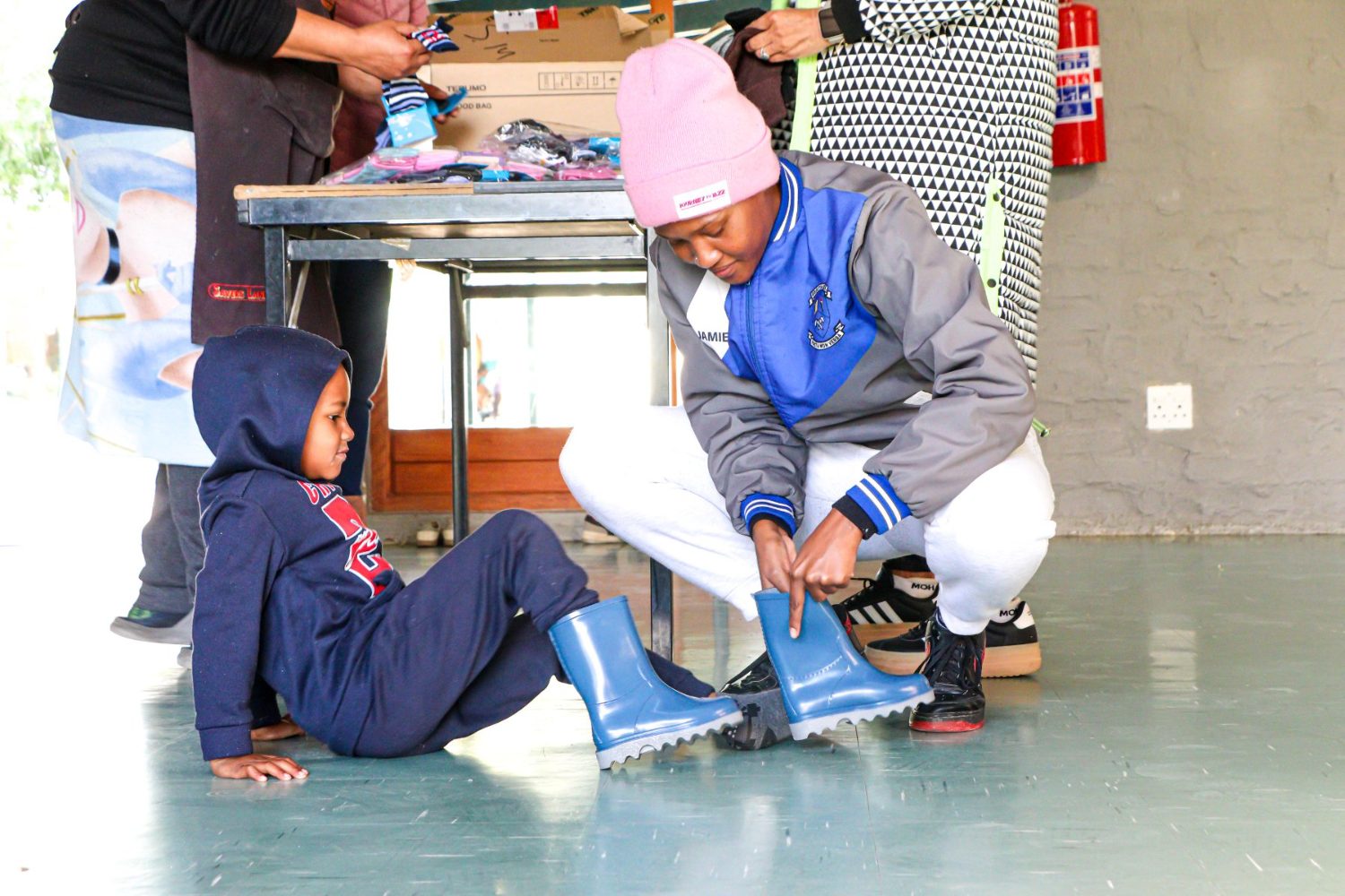 A child smiling with new pink and purple boots