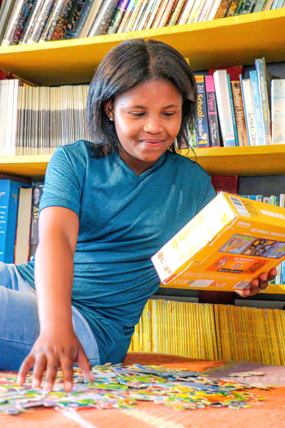 Candy-Lee doing a jigsaw puzzle by the library shelves