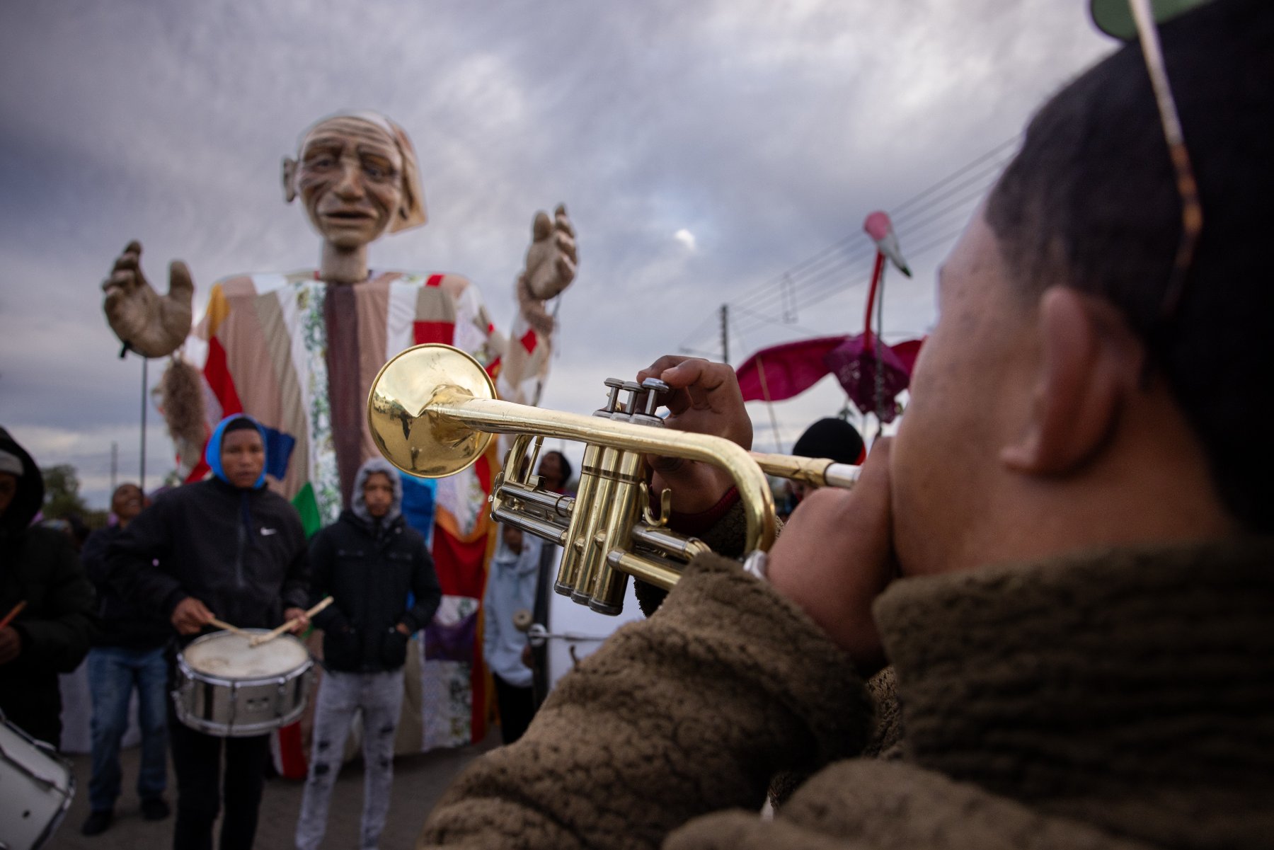 A trumpeter and the Outa Lappies puppet at a parade