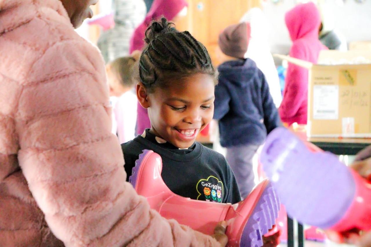 A child smiling with new rain boots