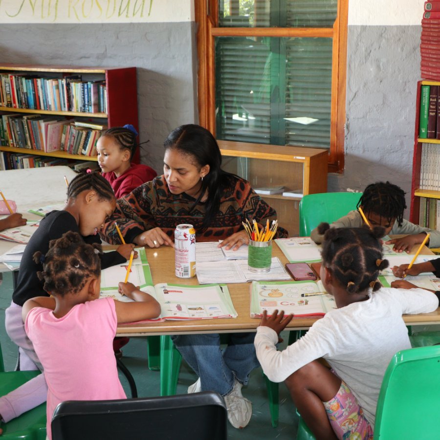A facilitator helping children with homework at the Centre