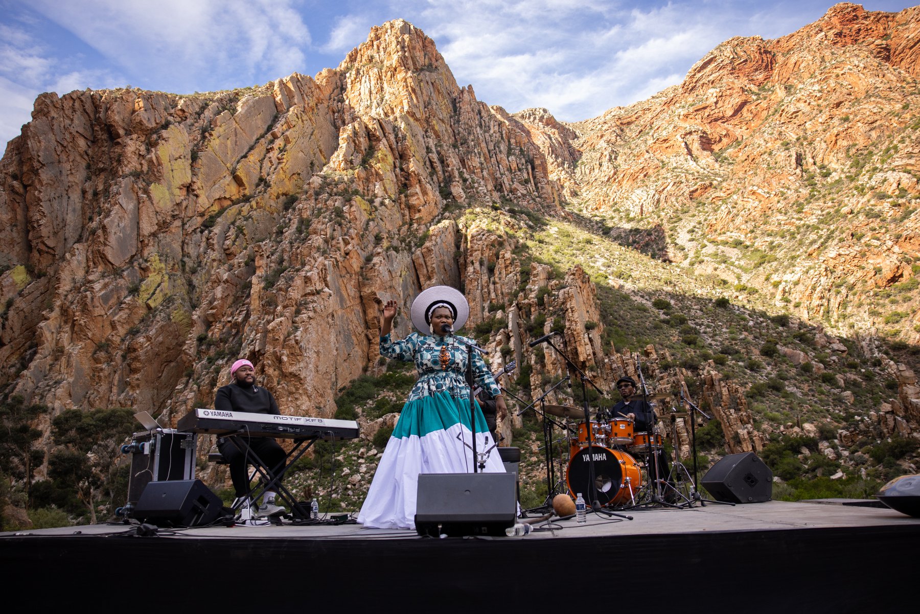 A vocalist and band performing on the Journey to Jazz stage against the Swartberg mountains