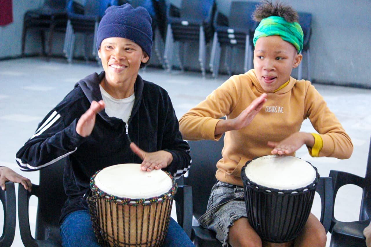 Two young drummers in a djembe session at the Leeu-Gamka Centre